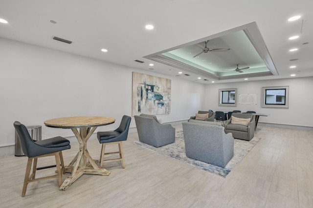 living room featuring ceiling fan and a tray ceiling