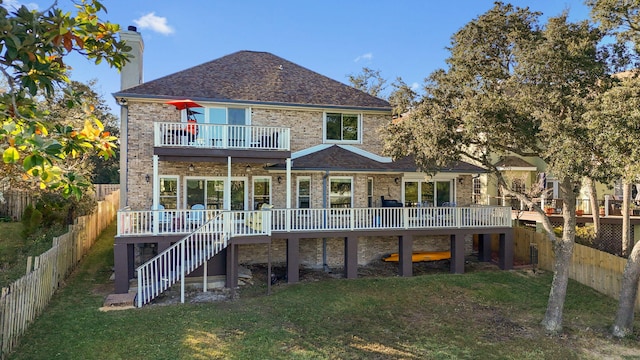 back of property with a deck, a fenced backyard, stairs, a lawn, and a chimney