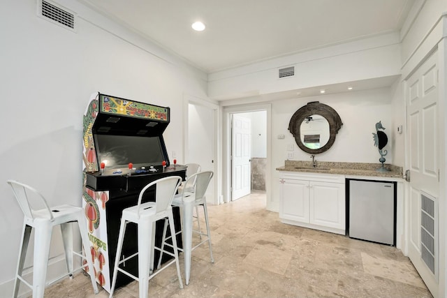 139 Brown St, Santa Rosa Beach, FL 32459 - interior space featuring sink, stainless steel fridge, white cabinetry, light stone countertops, and ornamental molding