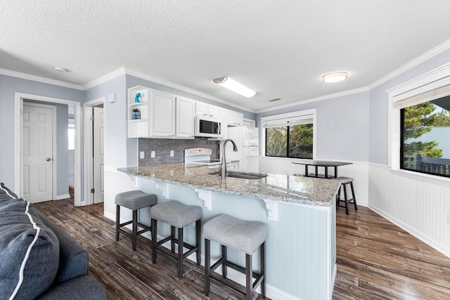 kitchen featuring light stone countertops, white cabinetry, dark hardwood / wood-style flooring, and white appliances