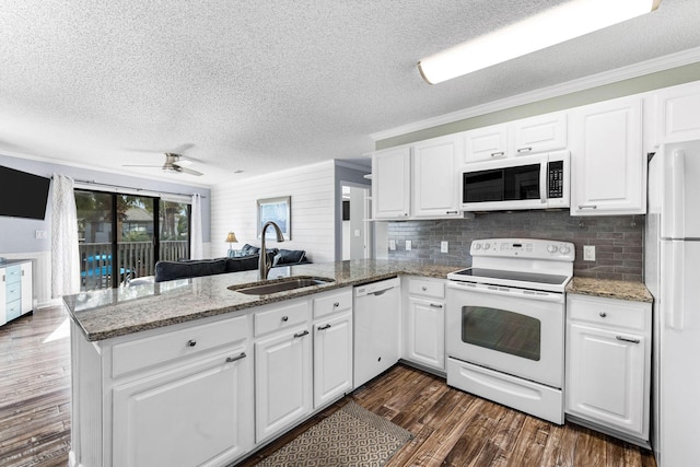 kitchen featuring sink, white cabinets, white appliances, and kitchen peninsula