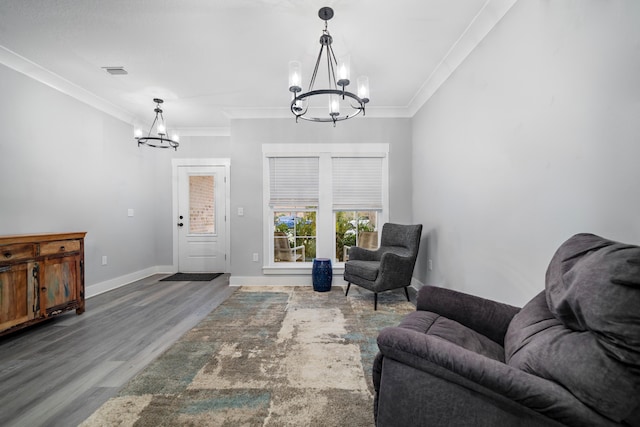 living area with baseboards, a chandelier, wood finished floors, and ornamental molding