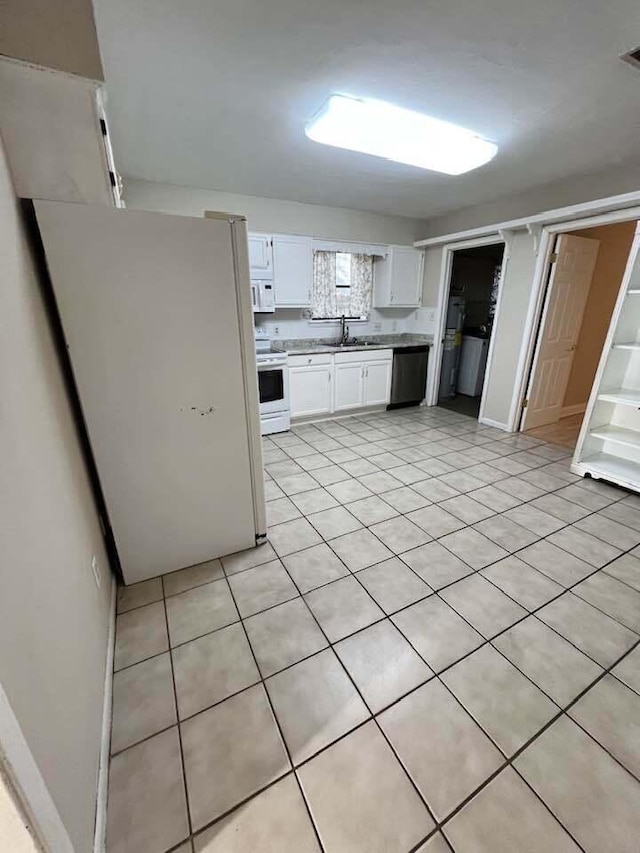 kitchen with light tile patterned flooring, white appliances, a sink, white cabinetry, and light countertops