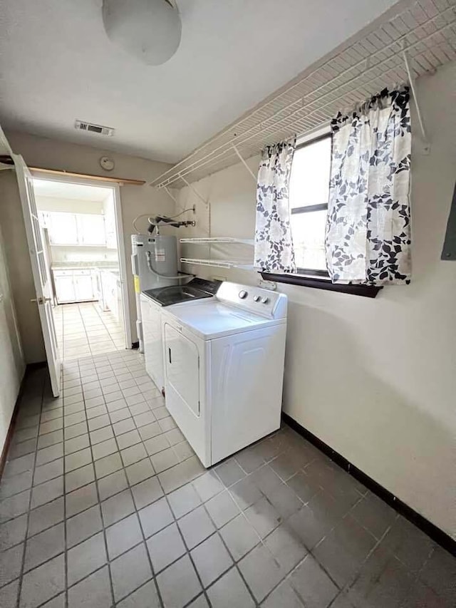 laundry area featuring tile patterned flooring, laundry area, separate washer and dryer, visible vents, and baseboards