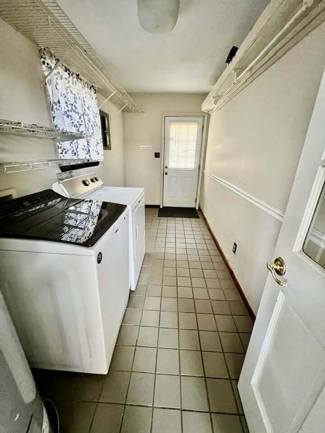 laundry area with laundry area, tile patterned floors, baseboards, and washing machine and clothes dryer