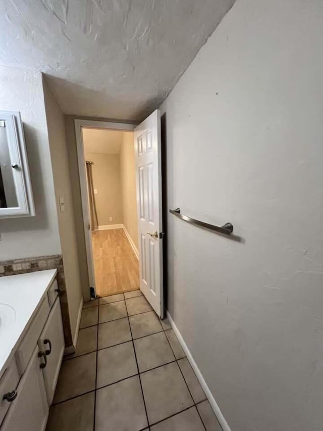 bathroom featuring tile patterned flooring, vanity, and baseboards