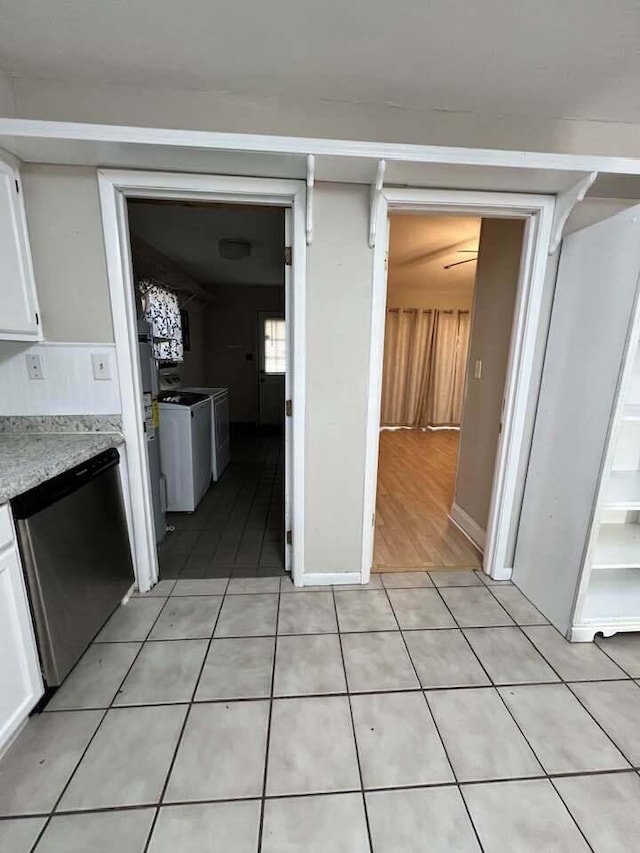 interior space with independent washer and dryer and light tile patterned flooring