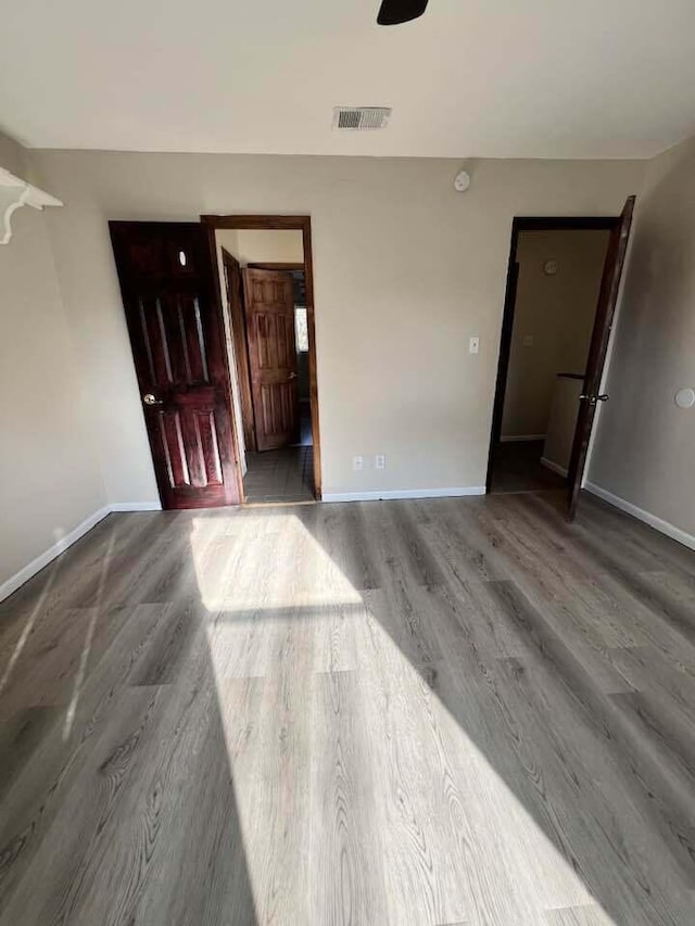 interior space featuring baseboards, visible vents, and wood finished floors