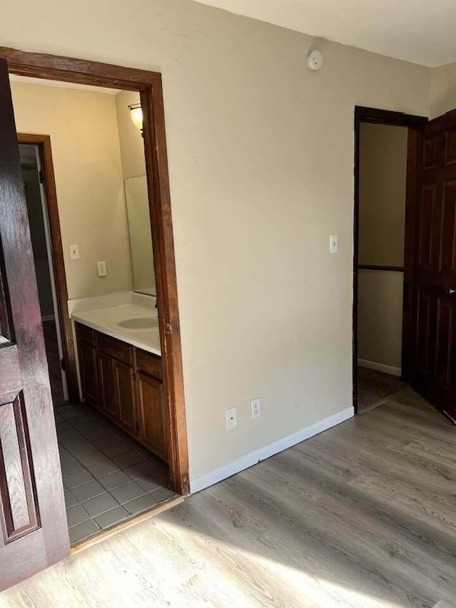 interior space featuring vanity, baseboards, and wood finished floors