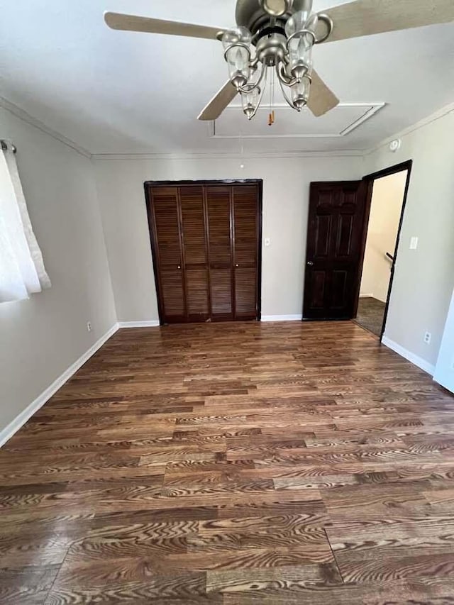 unfurnished bedroom featuring crown molding, baseboards, and wood finished floors