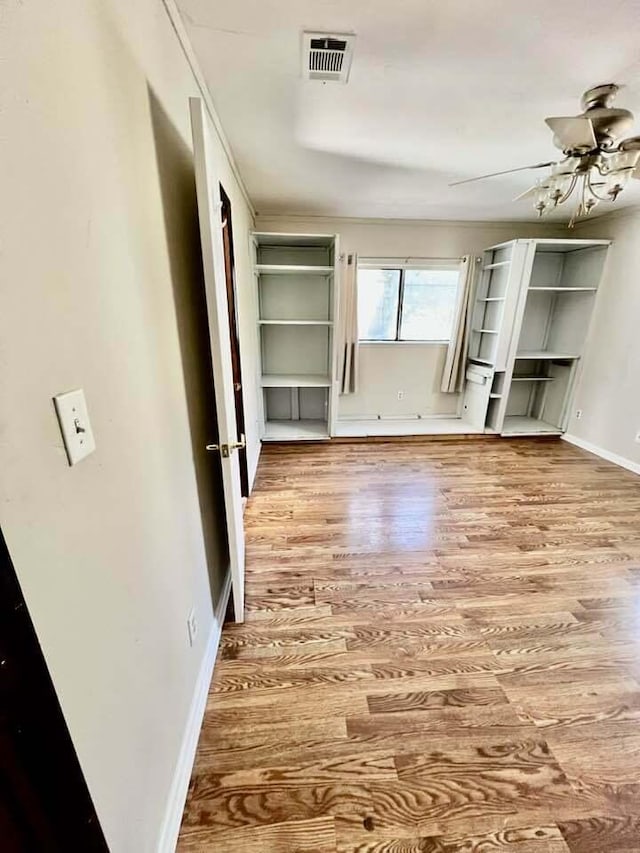 interior space with wood finished floors, visible vents, and baseboards