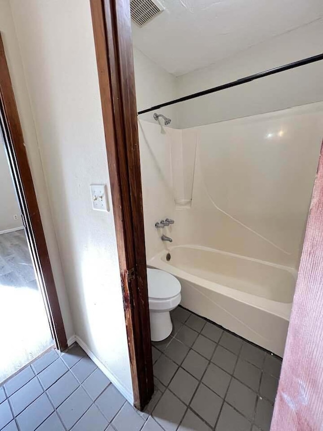 full bathroom featuring toilet, bathtub / shower combination, visible vents, and tile patterned floors