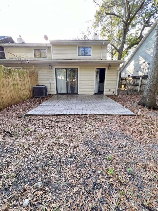 back of property featuring central air condition unit, a chimney, fence, and a patio