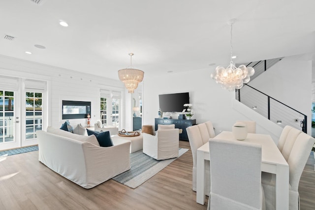 living room with an inviting chandelier and light hardwood / wood-style floors