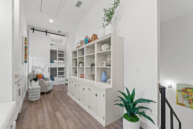 interior space with a barn door and light hardwood / wood-style floors