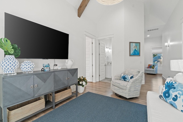 living room with beamed ceiling, high vaulted ceiling, and hardwood / wood-style flooring