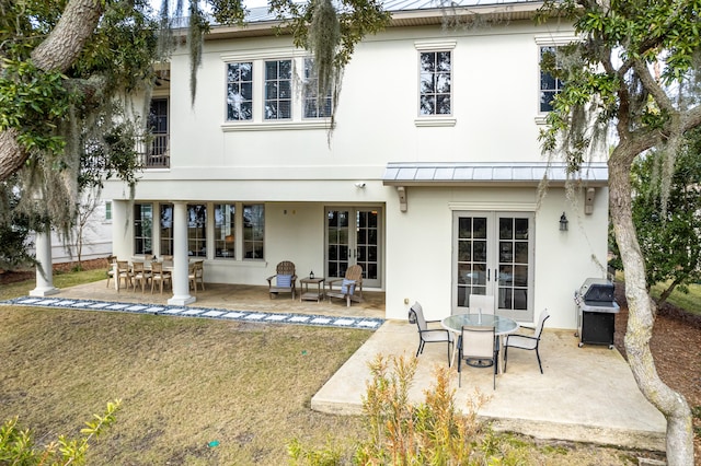 rear view of house featuring a patio, a yard, and french doors