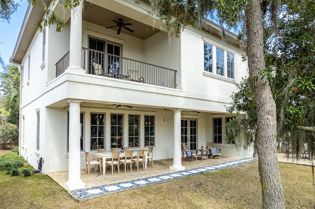 back of property featuring ceiling fan, a patio area, a balcony, and a lawn