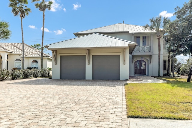 view of front facade featuring a garage, a front lawn, and french doors