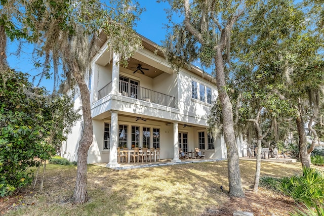 view of front of property with a patio, a balcony, ceiling fan, and a front lawn