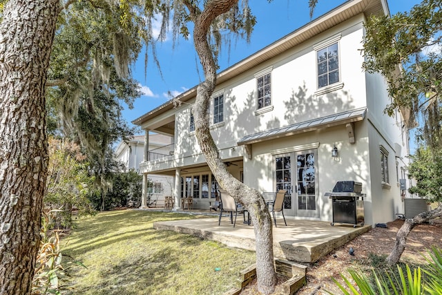 back of house featuring a yard, a patio, and a balcony