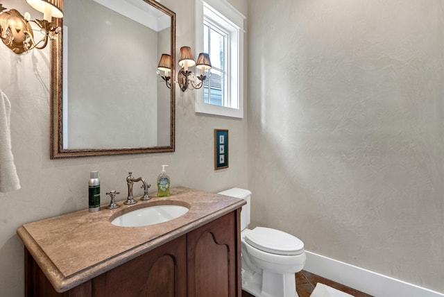 bathroom with vanity, a notable chandelier, and toilet