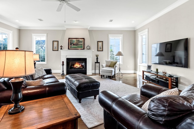 living room with a fireplace, ornamental molding, and ceiling fan