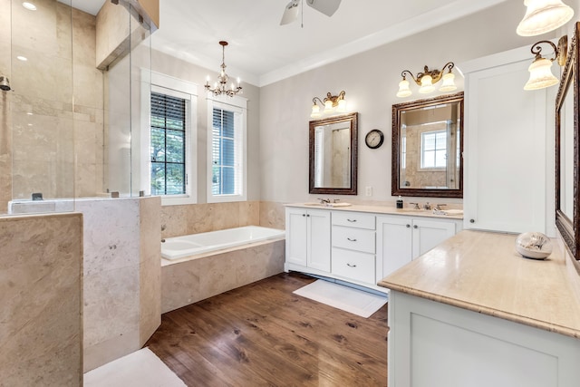 bathroom featuring an inviting chandelier, wood-type flooring, plus walk in shower, and vanity