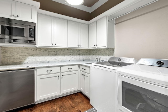 laundry area featuring independent washer and dryer, dark hardwood / wood-style floors, and sink