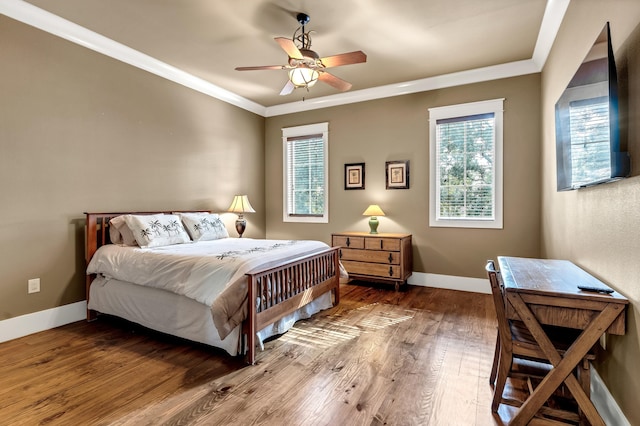 bedroom with ornamental molding, wood-type flooring, and ceiling fan