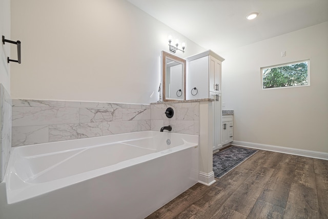 full bathroom featuring wood finished floors, recessed lighting, baseboards, a bath, and vanity