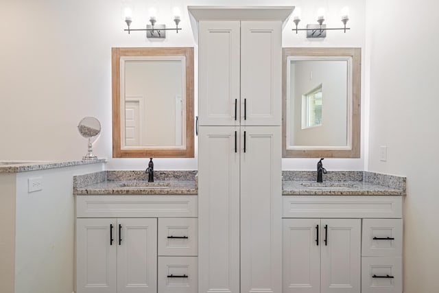 bathroom featuring a sink and two vanities