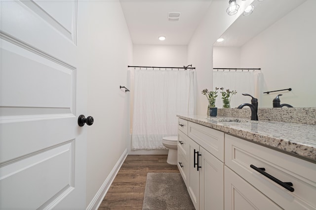 full bath with baseboards, toilet, a shower with shower curtain, wood finished floors, and vanity