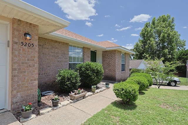 5205 Whitehurst Ln, Crestview, FL 32536 - doorway to property featuring brick siding, a yard, and a shingled roof