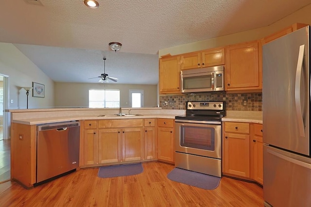 5205 Whitehurst Ln, Crestview, FL 32536 - kitchen with stainless steel appliances, a sink, a peninsula, ceiling fan, and light wood-type flooring
