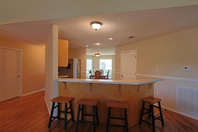 5205 Whitehurst Ln, Crestview, FL 32536 - kitchen featuring freestanding refrigerator, a kitchen breakfast bar, dark wood-type flooring, baseboards, and recessed lighting