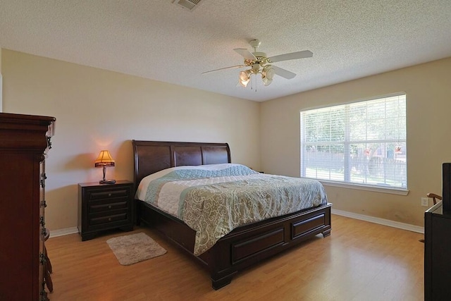 5205 Whitehurst Ln, Crestview, FL 32536 - bedroom featuring light wood-type flooring, baseboards, a textured ceiling, and ceiling fan