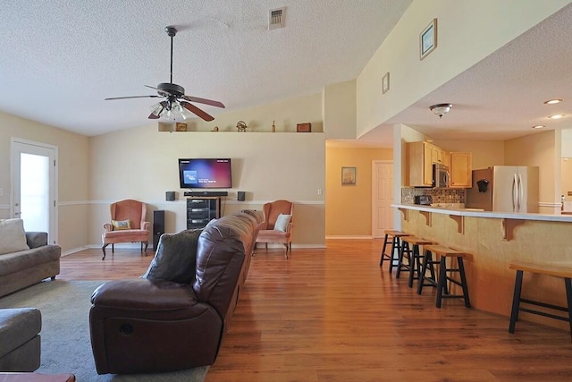 5205 Whitehurst Ln, Crestview, FL 32536 - living room featuring a textured ceiling, wood finished floors, a ceiling fan, lofted ceiling, and baseboards