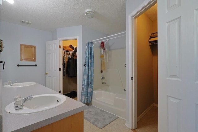 5205 Whitehurst Ln, Crestview, FL 32536 - bathroom featuring a walk in closet, shower / tub combo, a textured ceiling, and double vanity