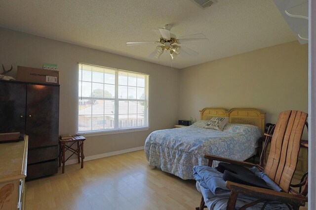 5205 Whitehurst Ln, Crestview, FL 32536 - bedroom featuring light wood-type flooring, baseboards, ceiling fan, and a textured ceiling
