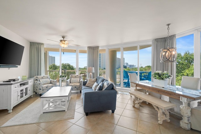 tiled living room featuring floor to ceiling windows and ceiling fan with notable chandelier