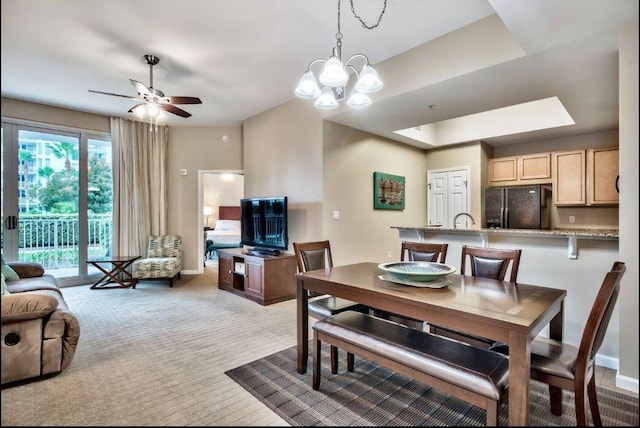 carpeted dining area with ceiling fan