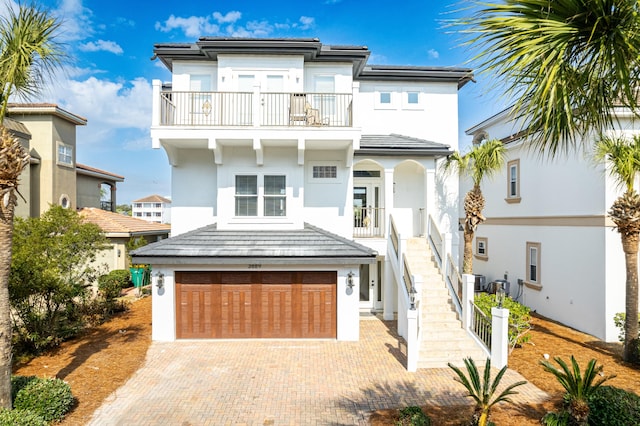 view of front of house with a garage, a balcony, and central AC