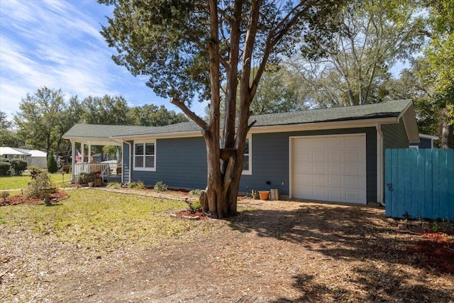 ranch-style home with an attached garage, driveway, and fence