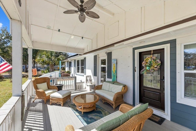 wooden terrace featuring an outdoor hangout area, a porch, and a ceiling fan