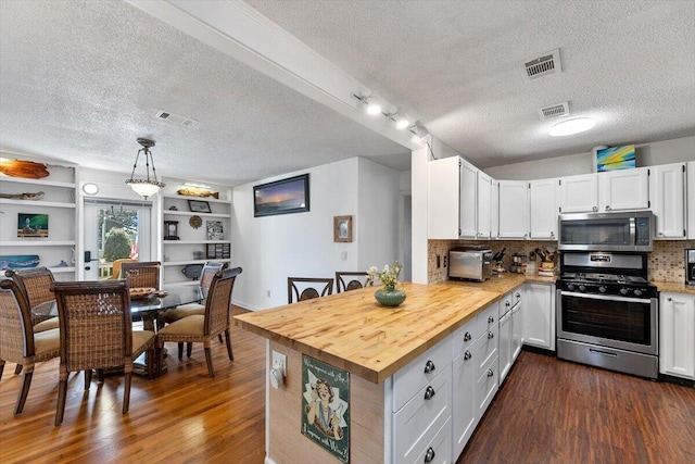 kitchen featuring appliances with stainless steel finishes, dark wood-style flooring, and visible vents