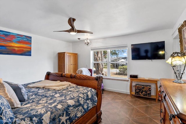 bedroom with a ceiling fan, dark tile patterned flooring, and baseboards