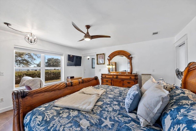 bedroom featuring baseboards, visible vents, and ceiling fan with notable chandelier