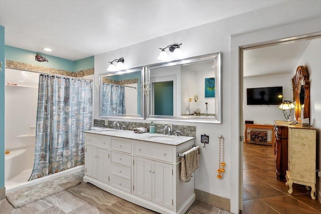 full bathroom with a sink, a shower with shower curtain, and double vanity