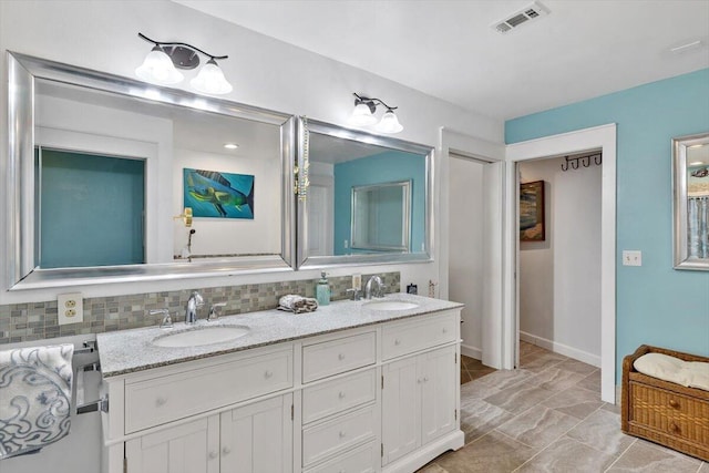 full bath with double vanity, tasteful backsplash, visible vents, and a sink